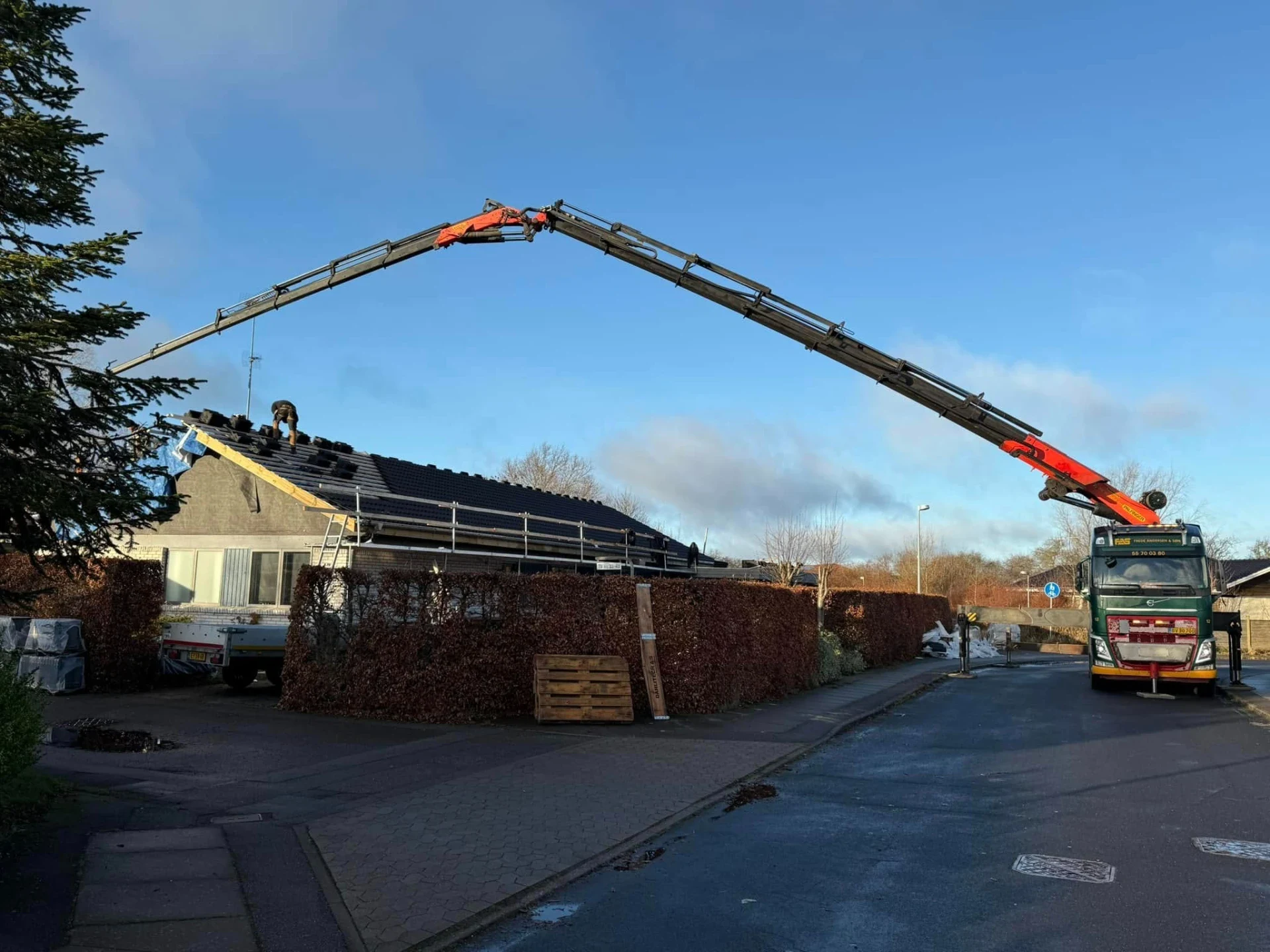 Byggekran løfter materialer på byggepladsen i dag.
