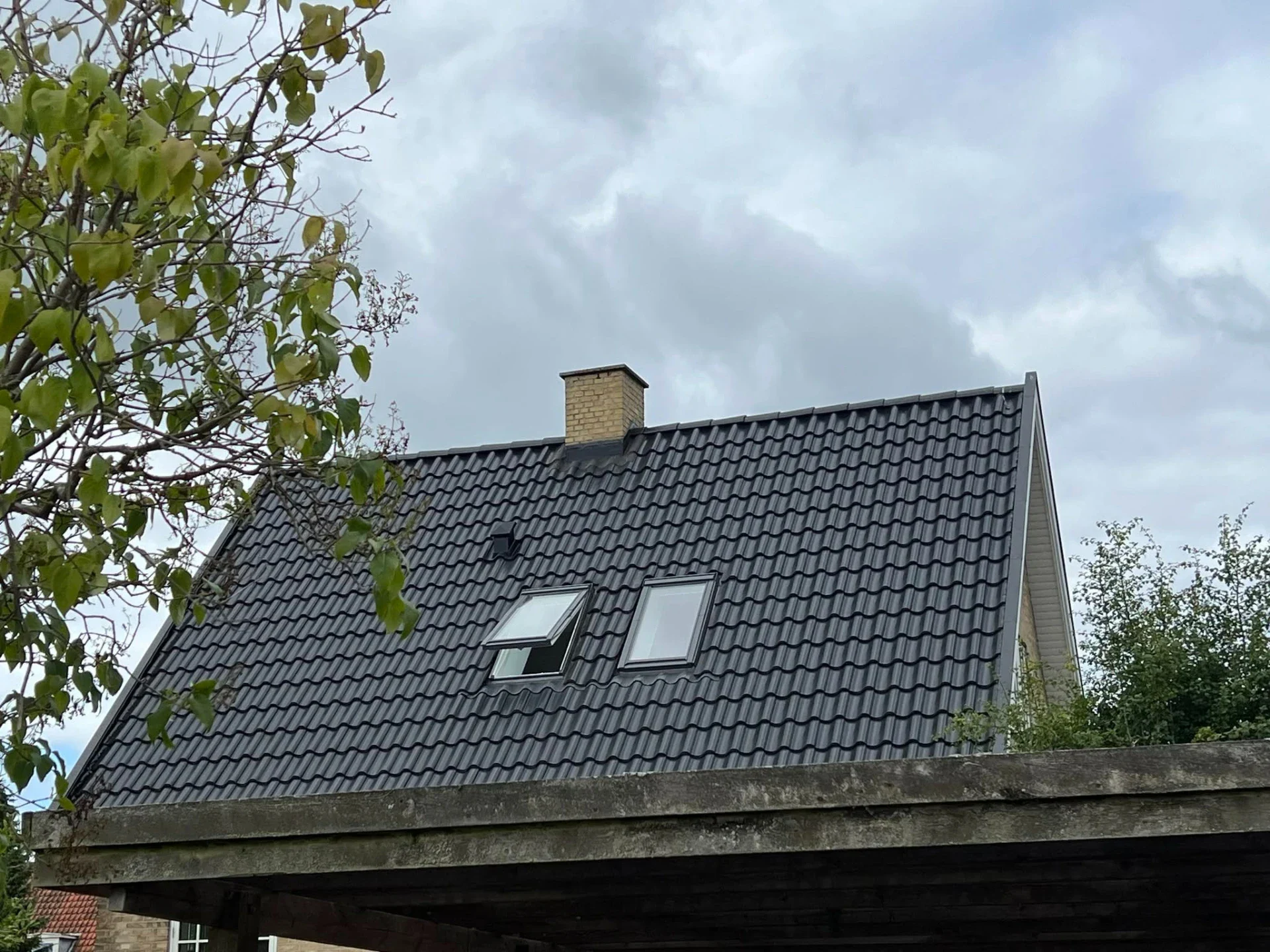Tagdækning med sort tagsten på nyt hus af JanRa ApS.