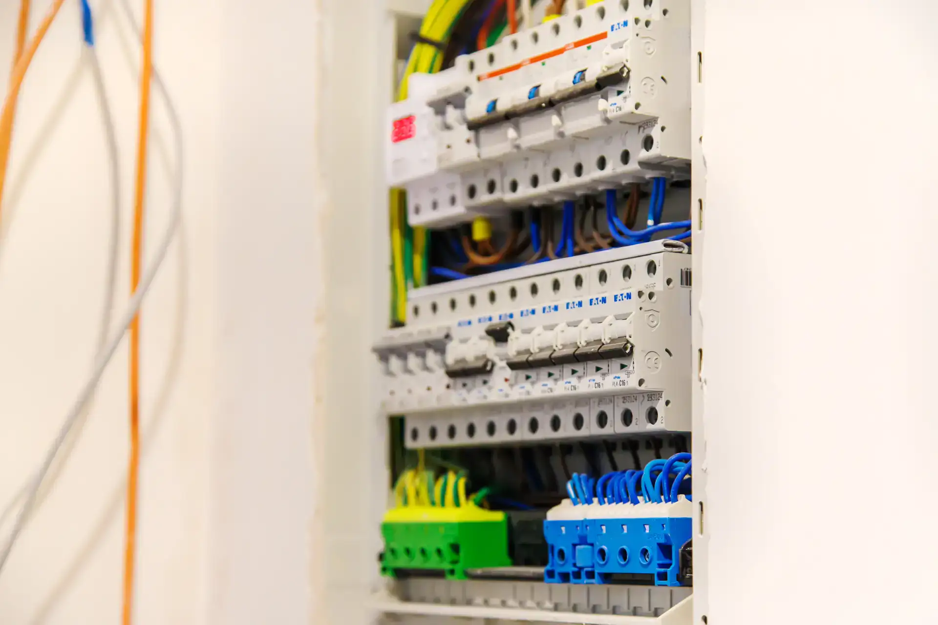 Elektrisk tavle med farvede ledninger og sikringer.